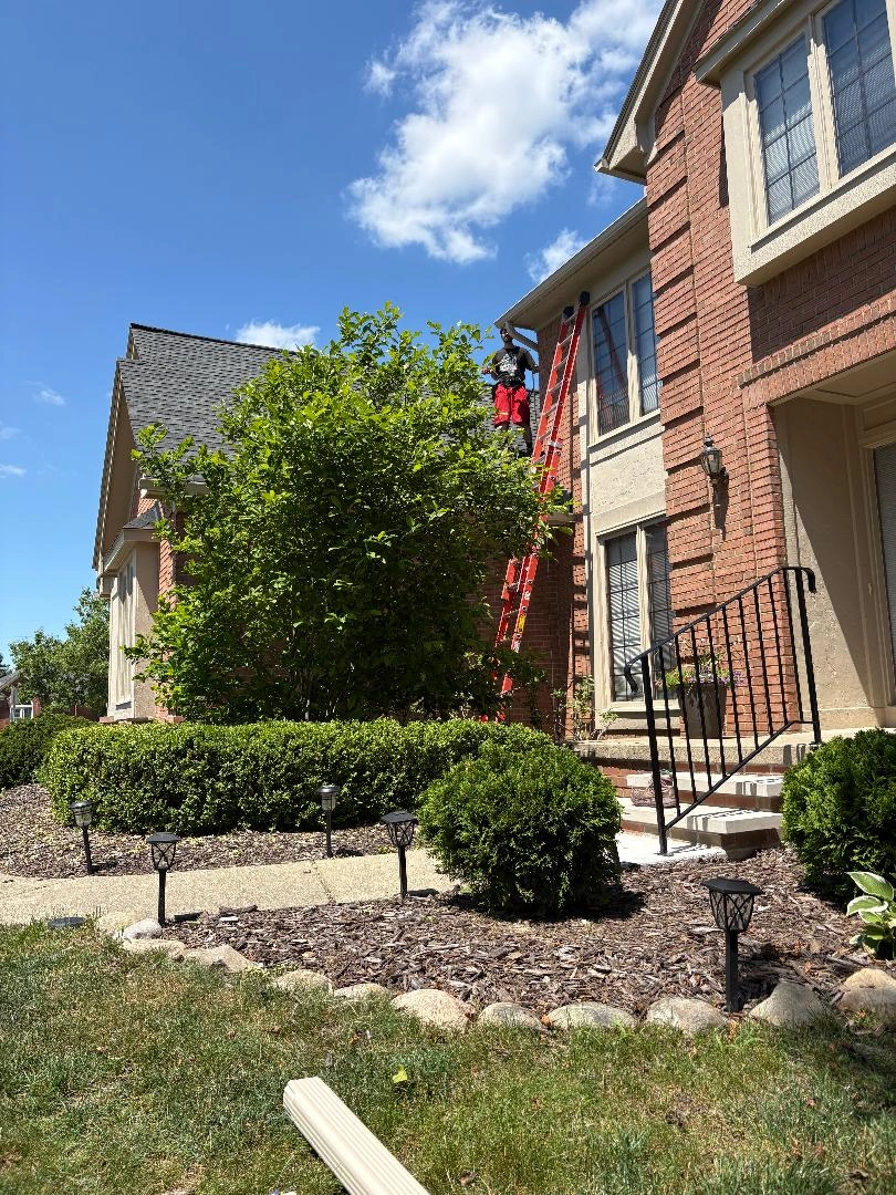 Professional gutter maintenance and installation on a brick home ensures proper drainage 810-343-5551